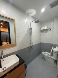 a bathroom with a sink and a toilet and a mirror at Madam Thu House in Hue +50 photos