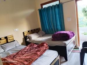 a room with two beds and a window with blue curtains at Himadri Homestay Sari Devriyatal in Sari