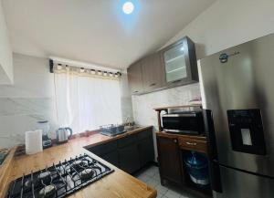 a kitchen with a stove and a refrigerator at Casa Orquídeas Oaxaca in Oaxaca City