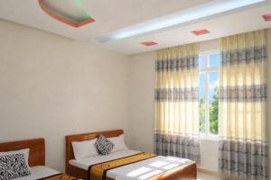 ein Schlafzimmer mit zwei Betten und einem Fenster in der Unterkunft Hải Long Motel Phú Thọ in Phú Thọ