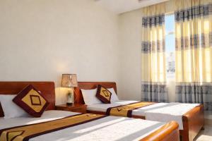 ein Schlafzimmer mit zwei Betten und einem Fenster in der Unterkunft Hải Long Motel Phú Thọ in Phú Thọ