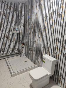 a bathroom with a toilet in front of a fence at ASR HOSTEl in Andizhan