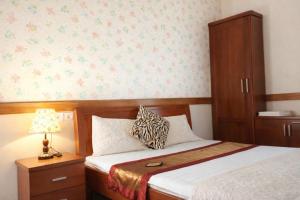 ein Schlafzimmer mit einem Bett mit einem Schrank und einer Lampe in der Unterkunft Hải Long Motel Phú Thọ in Phú Thọ + 9 Fotos