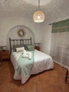 a bedroom with a bed with two towels on it at Bike Cueva - Badlands in Gorafe
