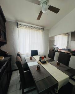 a dining room table with chairs and a ceiling fan at Casa Orquídeas Oaxaca in Oaxaca City