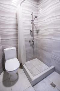 a white bathroom with a toilet and a shower at MBM Hotel in Yerevan +38 photos