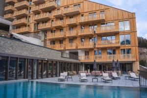 een hotel met een zwembad voor een gebouw bij Guernerés & Spa by Alpine Resorts in Grimentz