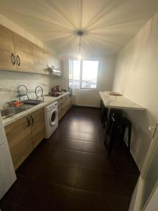 een keuken met een wastafel en een tafel met een wasmachine bij Le Florimorizon in Le Havre