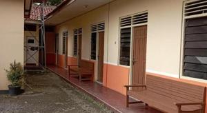a wooden bench sitting outside of a building at Hotel O Guest House Wijaya Syariah Near alun alun kota purwokerto in Purwokerto