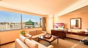 a living room with a couch and a large window at Bell Tower Hotel in Xi'an