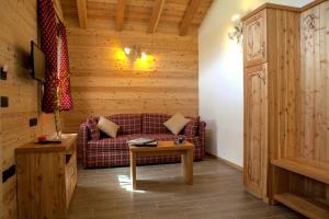 un soggiorno con un divano e un tavolo di Chalet Eco-Lodge Faè a Madonna di Campiglio