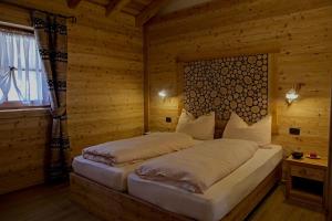 una camera da letto con un letto in una stanza di legno di Chalet Eco-Lodge Faè a Madonna di Campiglio