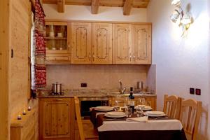 una cucina con mobili in legno e un tavolo con sedie di Chalet Eco-Lodge Faè a Madonna di Campiglio