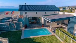 een bovenaanzicht van een huis met een zwembad bij Romansbaai Oceanview Retreat in Gansbaai +28 foto's