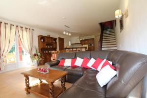 een woonkamer met een leren bank met rode en witte kussens bij Errotalde-berria in Sare