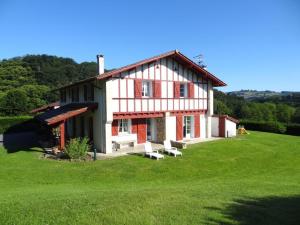 een huis op een heuvel met een groen veld bij Errotalde-berria in Sare