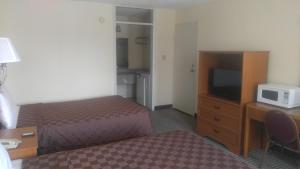a hotel room with a bed and a tv at Americourt Extended Stays in Kingsport