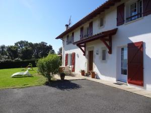 une maison blanche avec des portes rouges et une cour dans l'établissement Errotalde-berria bi, à Sare
