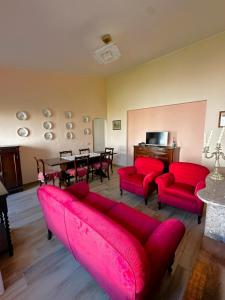 een woonkamer met rode banken en een eetkamer bij Dimora Sulle Mura in Anagni
