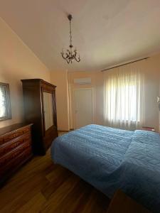 een slaapkamer met een blauw bed en een kroonluchter bij Dimora Sulle Mura in Anagni