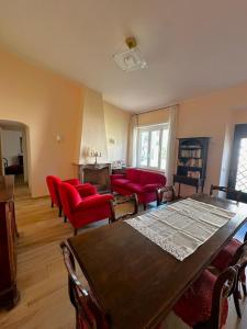 een woonkamer met rode stoelen en een houten tafel bij Dimora Sulle Mura in Anagni