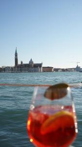 a glass of wine sitting on top of the water at Gabrielli Luxury Apartments Venezia - Starhotels Collezione in Venice