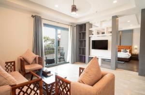 a living room with a couch and a tv at Dhauladhar Heights Resort in Dharamshala