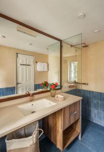 een badkamer met een wastafel en een spiegel bij Sanctuary by RÊVE Escapes - Premium 3 BHK Villa with Private Pool Near Morjim Beach in Siolim