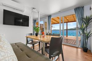 a living room with a dining room table with a view of the ocean at Sibenik Resort in Šibenik