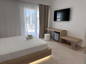 una camera da letto con un letto e una TV a schermo piatto di Relais Dolce Vita a Porto Cesareo