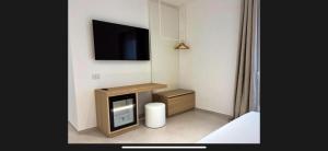una piccola stanza con una TV e un mobile porta TV di Relais Dolce Vita a Porto Cesareo Altre 8 foto