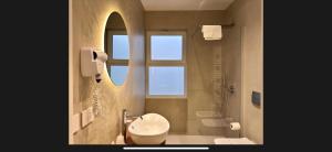 un bagno con lavandino, WC e specchio di Relais Dolce Vita a Porto Cesareo