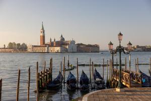 a group of gondolas in the water near a pier at Gabrielli Luxury Apartments Venezia - Starhotels Collezione in Venice