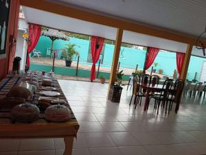 a long table in a restaurant with a view of the beach at Pousada raio de sol in Barreirinhas