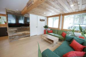 un salon avec un canapé et une télévision à écran plat dans l'établissement Spa et Waterfront - Cachette du Petit Lac, à Chertsey