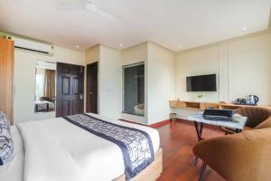 een slaapkamer met een bed, een bank en een tv bij Hotel Dua Grand A unit of Ajooni Hospitality- 5 Min Walk From Golden Temple in Amritsar