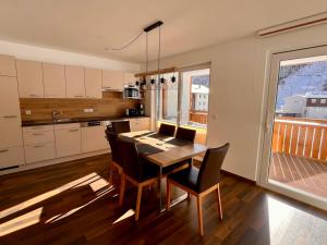 a kitchen with a table and chairs and a kitchen with a balcony at Ramsaublick in Ramsau am Dachstein