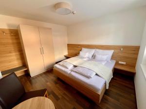 a bedroom with a bed with white sheets and pillows at Ramsaublick in Ramsau am Dachstein +23 photos