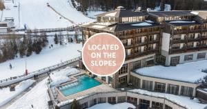 a hotel with a sign that reads lodged on the slopes at Falkensteiner Aktiv & Familienhotel Cristallo in Katschberghöhe