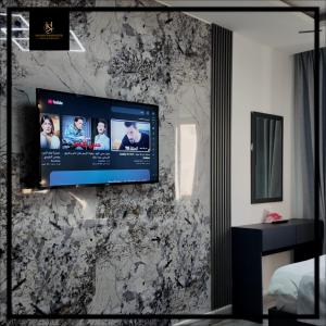 una TV appesa a un muro in una camera da letto di Holiday Season Hotel ad Aqaba Altre 19 foto