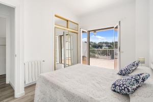 une chambre blanche avec un lit et un balcon dans l'établissement Villa Can Ernest, à Cala Galdana 32 autres photos