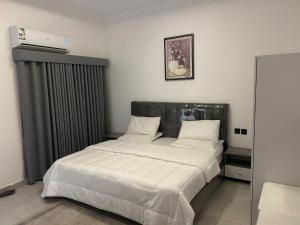 a bed with white sheets and pillows in a room at قمرة قباء Quba moon4 in Medina