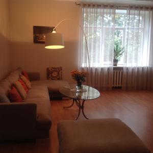 a living room with a couch and a glass table at Apartment on Riepnieku Street in Riga