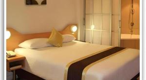 a bedroom with a large white bed with two pillows at Peninsula International Hotel in The Domain +91 photos