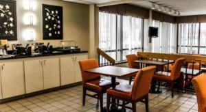 a dining room with tables and chairs and a kitchen at Roanoke near Lake Gaston in Weldon