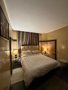 a bedroom with a large bed and two lamps at Welcome to your Stylish apartment in Oulad Akkou