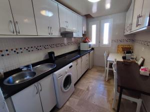 a kitchen with a sink and a washing machine at Seule résidence accès directe plage in Saïdia