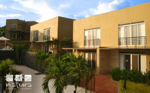 a building with palm trees in front of it at Natura Reservado - Hoteles Natura in Anapoima