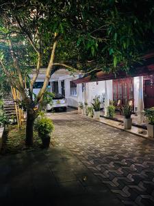 a tree in front of a building with a driveway at Bliss Haven Transit Hotel in Negombo