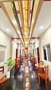 een restaurant met houten tafels en houten stoelen bij SANJH Island Hotel powered by Cocotel in Roxas